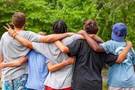 campers with back turned in a group hug